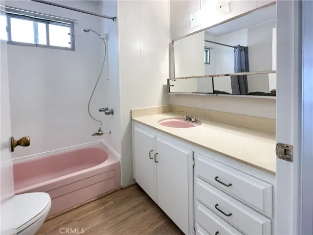 a bathroom with a tub sink and toilet