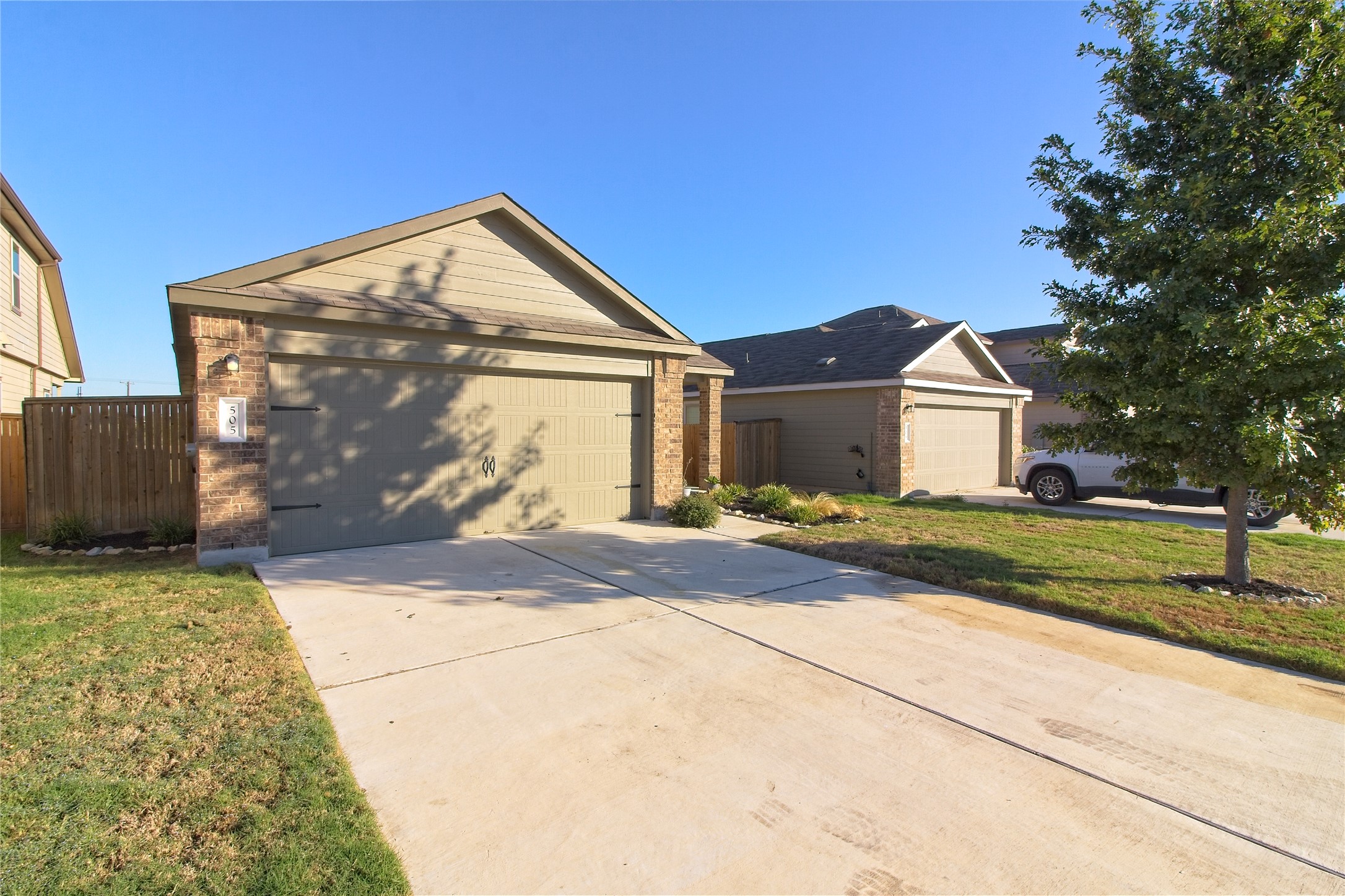 505 Greatest Gift Way Jarrell, TX 76537 - Photo 3 of 30 Ranch-style home featuring brick siding, concrete driveway, and an outdoor structure