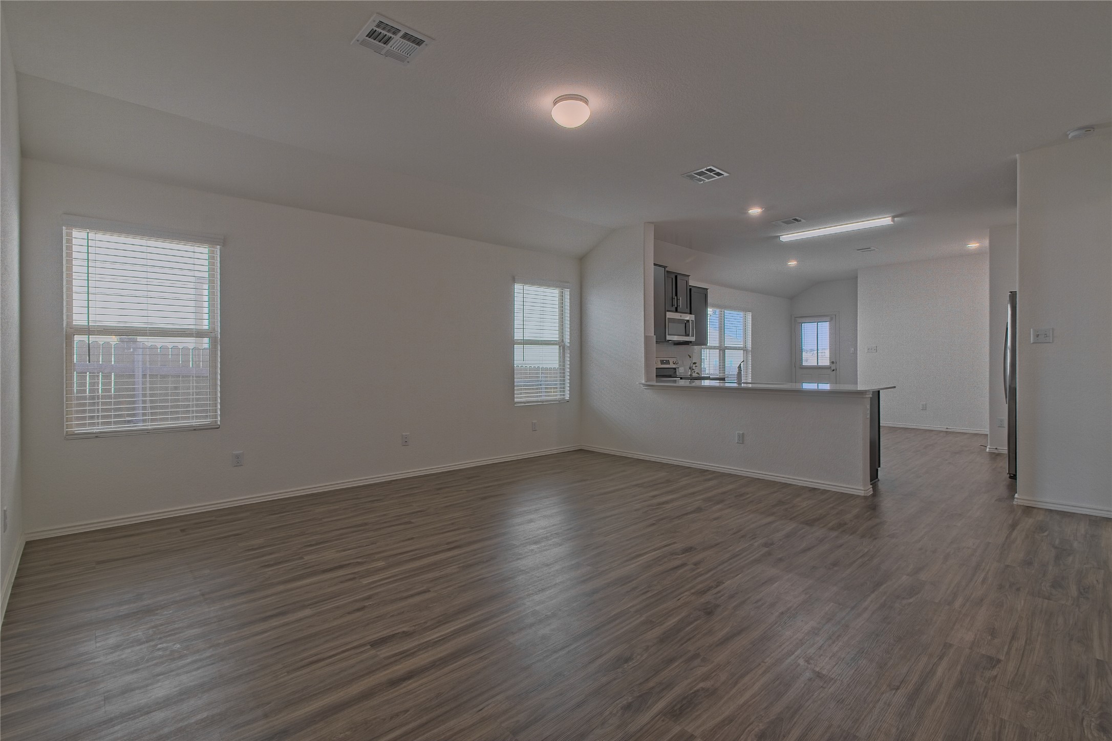 505 Greatest Gift Way Jarrell, TX 76537 - Photo 6 of 30 Unfurnished living room with dark wood finished floors and lofted ceiling