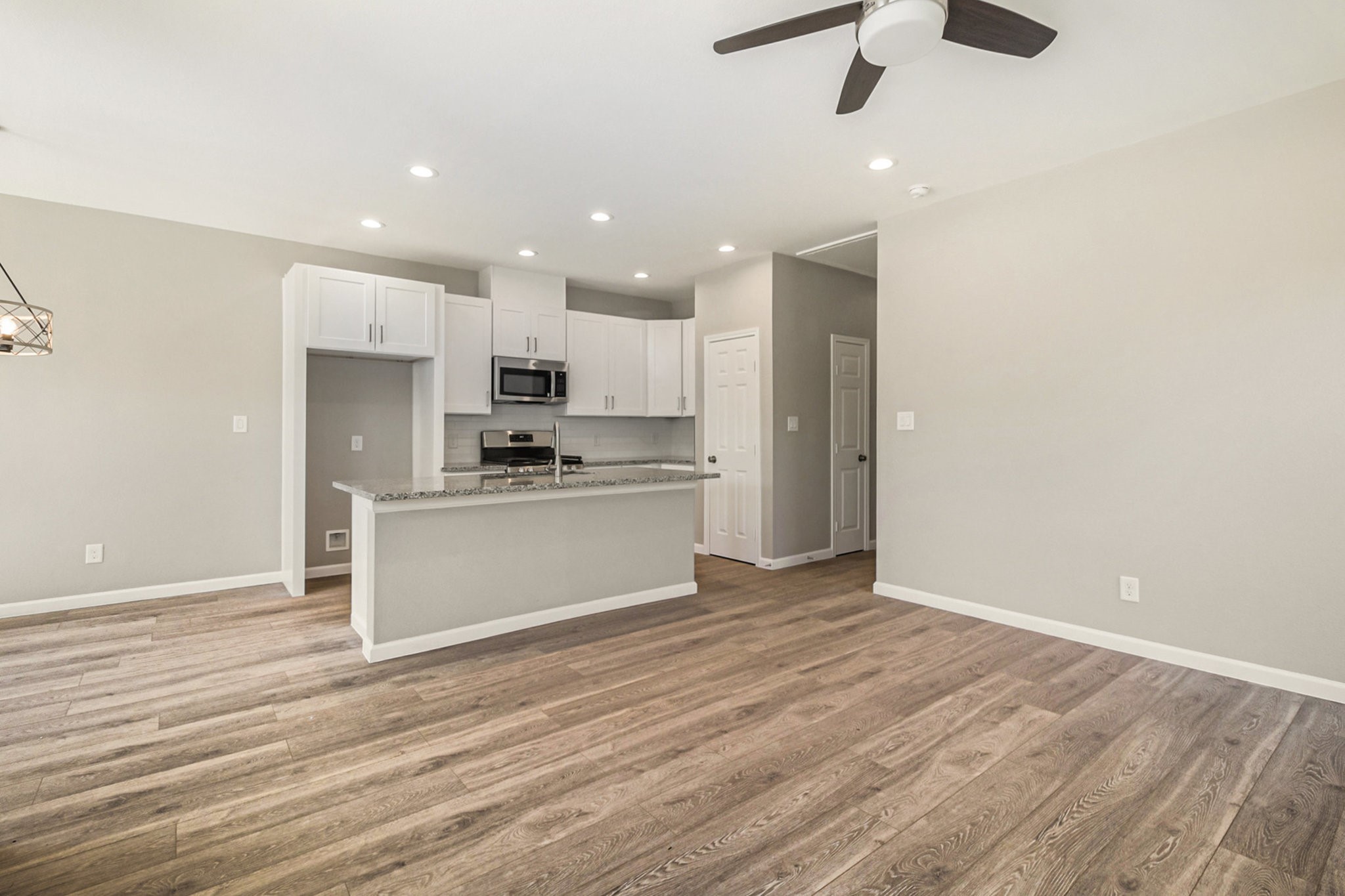 4645 Larkspur Street Houston, TX 77051 - Photo 6 of 16 an empty room with wooden floor kitchen view and a window