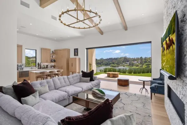a living room with furniture floor to ceiling window hardwood floor and a flat screen tv
