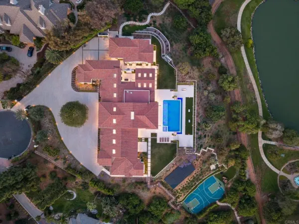 an aerial view of a house with a yard and lake view