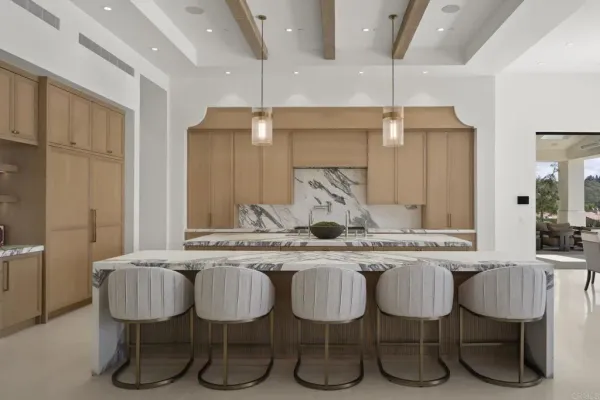 a kitchen with a dining table chairs sink and cabinets