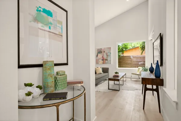 a living room with furniture and a painting on the wall