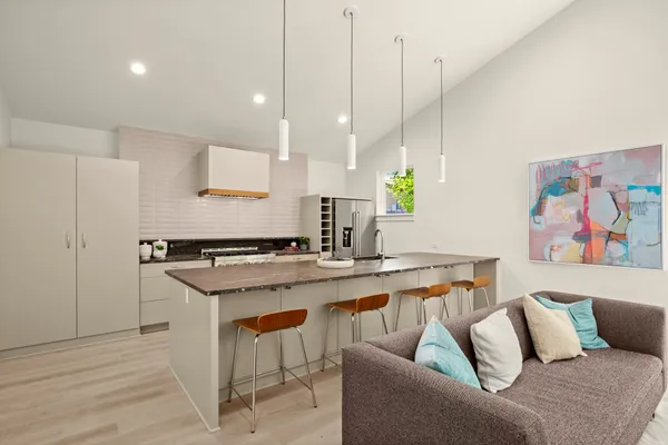 a view of kitchen with stainless steel appliances granite countertop sink stove and white cabinets
