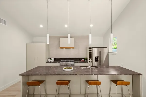 a kitchen with kitchen island stainless steel appliances a sink and white cabinets