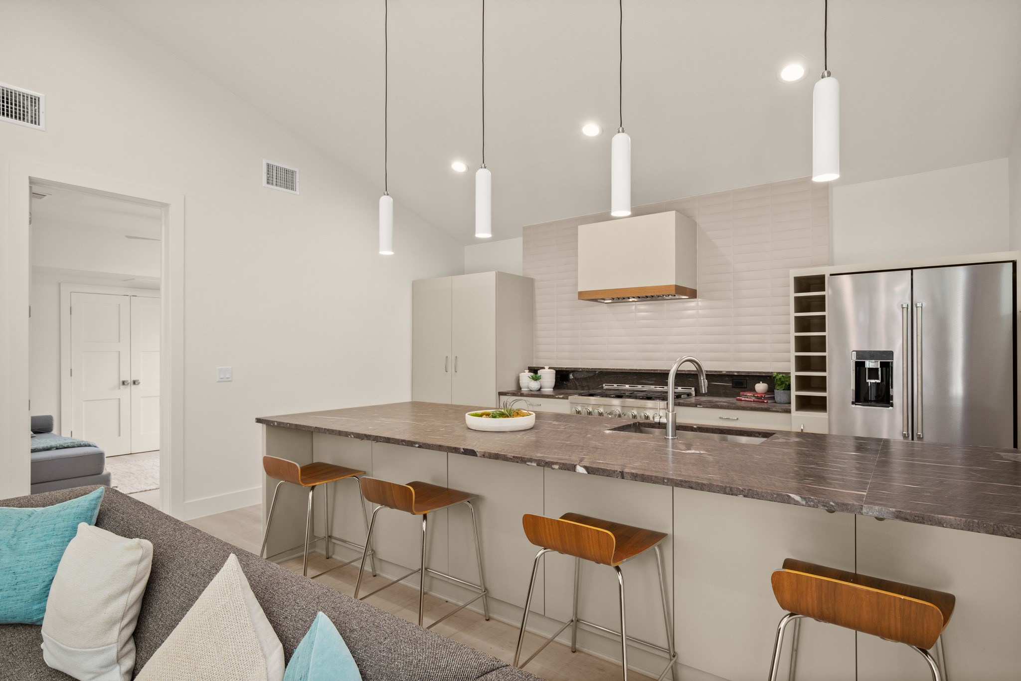 3003 Ray Wood Drive, Unit 2 Austin, TX 78704 - Photo 14 of 28 Kitchen with lofted ceiling, high quality fridge, a kitchen breakfast bar, pendant lighting, and backsplash
