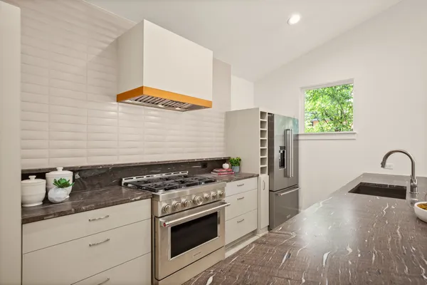 a kitchen with granite countertop a stove and a refrigerator