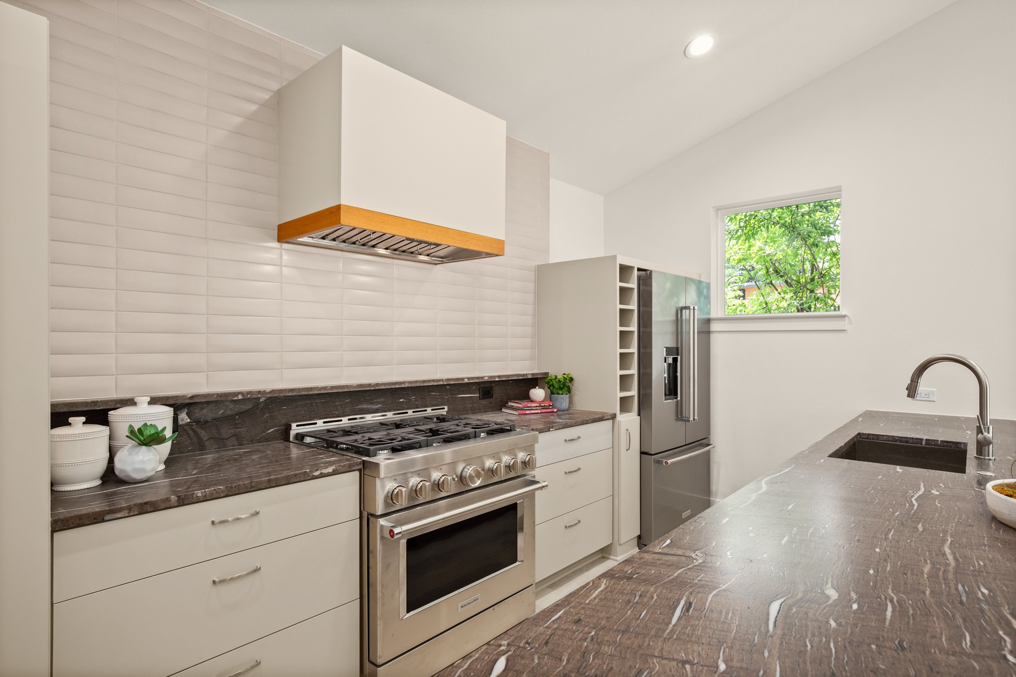 3003 Ray Wood Drive, Unit 2 Austin, TX 78704 - Photo 15 of 28 Kitchen with high end appliances, dark stone countertops, tasteful backsplash, lofted ceiling, and recessed lighting