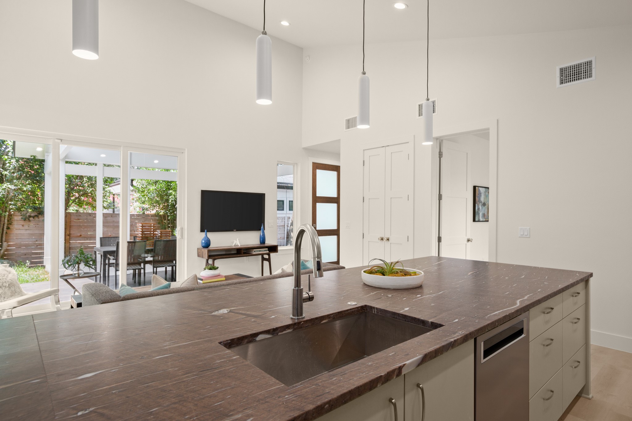 3003 Ray Wood Drive, Unit 2 Austin, TX 78704 - Photo 27 of 28 Kitchen with pendant lighting, dark stone countertops, dishwasher, open floor plan, and vaulted ceiling