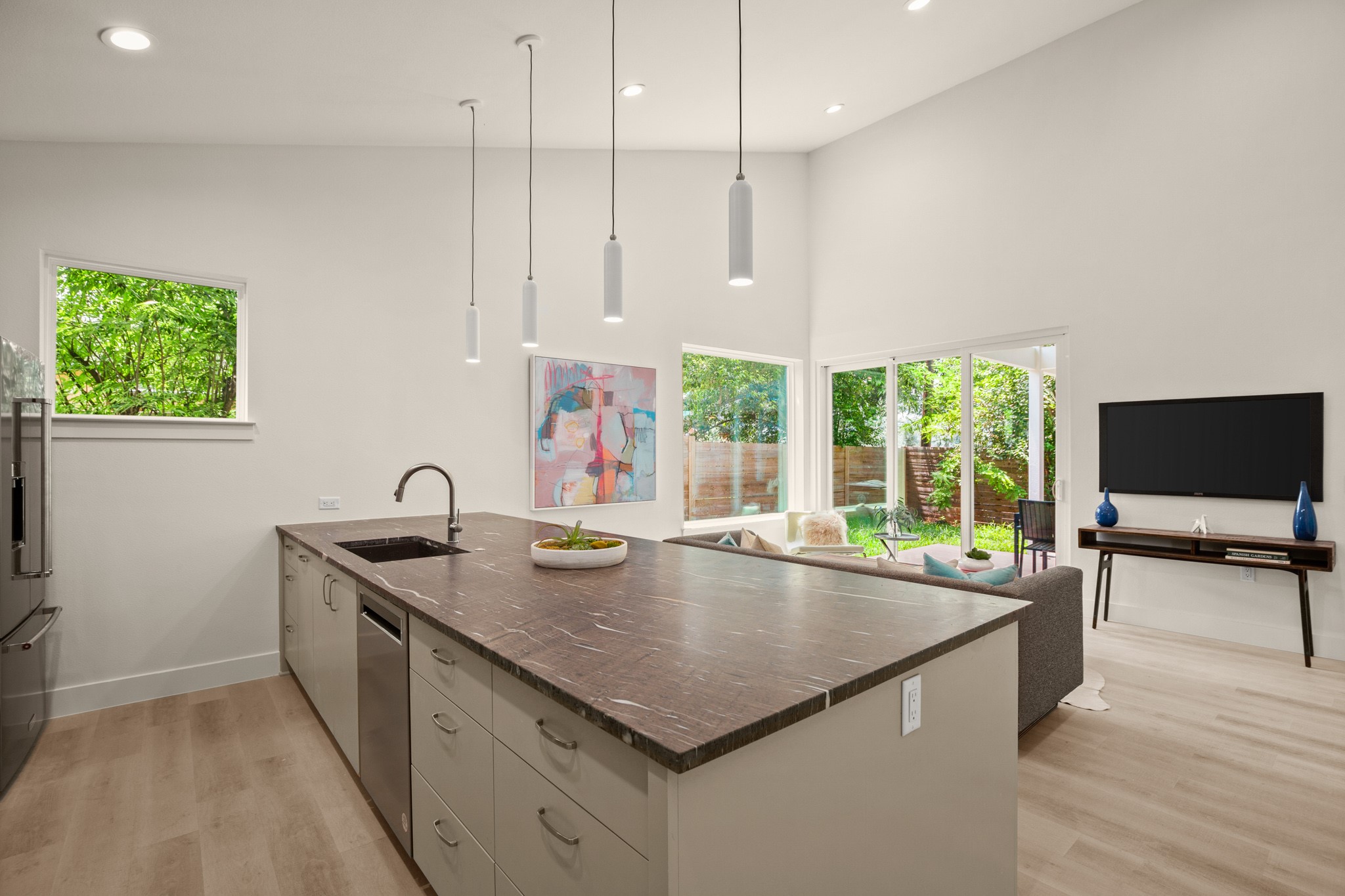 3003 Ray Wood Drive, Unit 2 Austin, TX 78704 - Photo 28 of 28 Kitchen featuring a peninsula, light wood-style flooring, open floor plan, stainless steel appliances, and hanging light fixtures