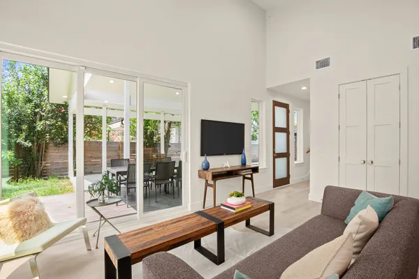 a living room with furniture a flat screen tv and a large window