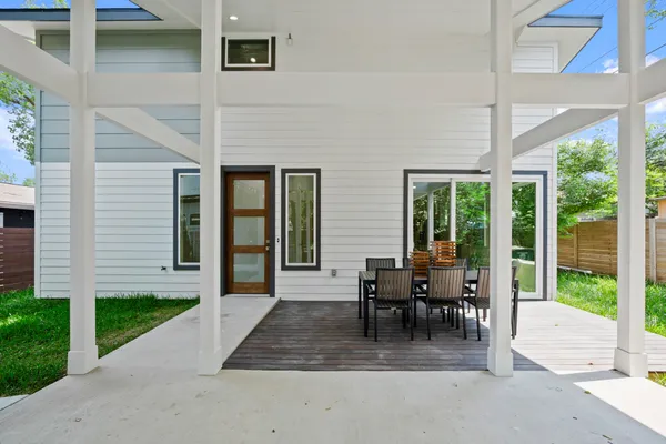 a view of a patio with table and chairs and floor to ceiling window