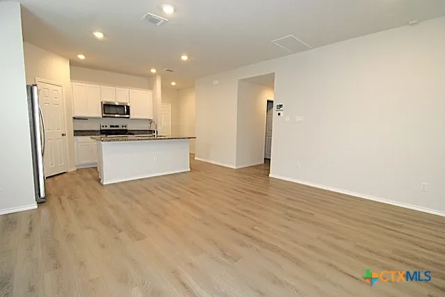 a kitchen with stainless steel appliances a refrigerator and a stove top oven