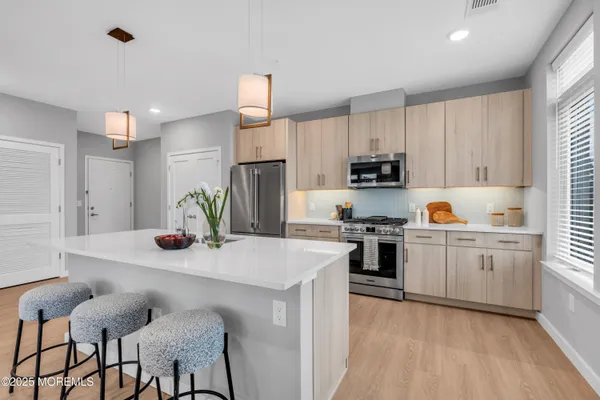 a kitchen with granite countertop white cabinets and stainless steel appliances