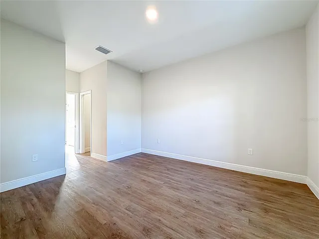 a view of an empty room and wooden floor