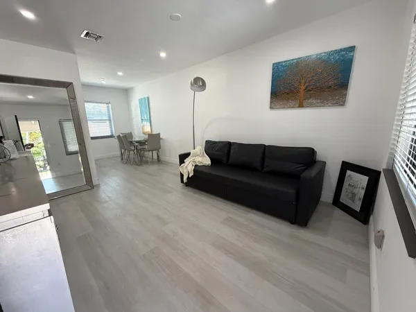 a living room with furniture and a wooden floor