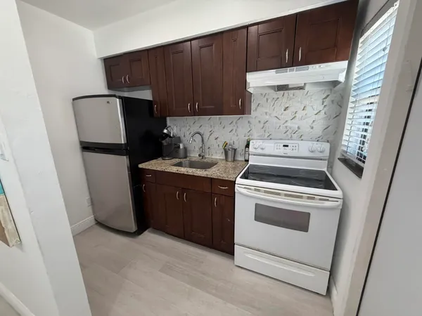 a kitchen with a refrigerator sink and cabinets