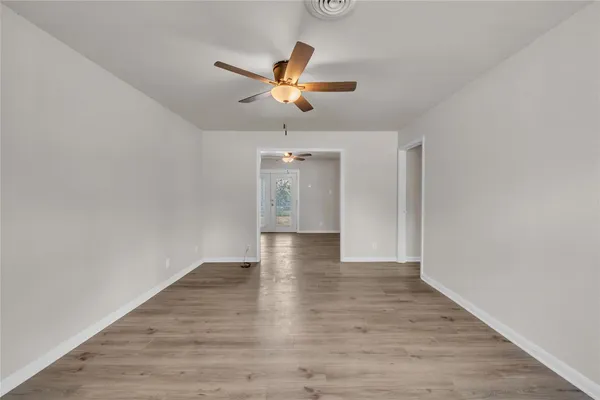 a view of empty room with wooden floor