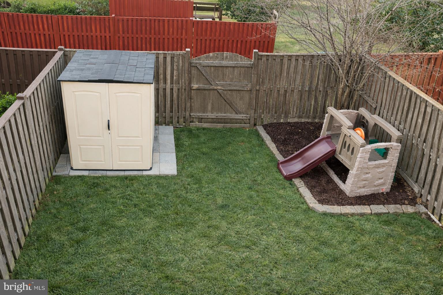 8476 Tackhouse Loop Gainesville, VA 20155 - Photo 16 of 16 a view of backyard with wooden fence and a bench