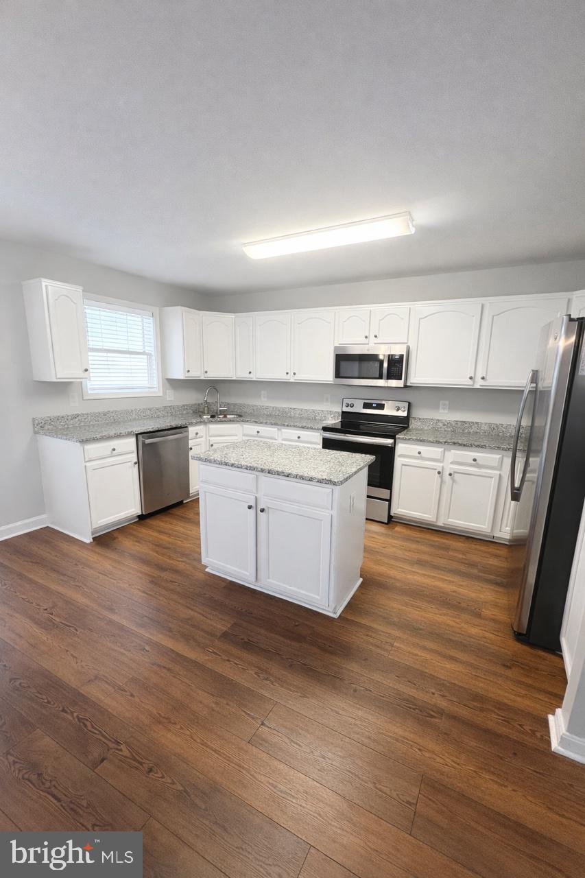 8476 Tackhouse Loop Gainesville, VA 20155 - Photo 6 of 16 a kitchen with stainless steel appliances granite countertop a stove a sink dishwasher and a refrigerator