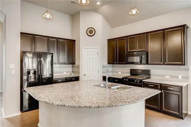 a kitchen with stainless steel appliances granite countertop a sink a stove and microwave
