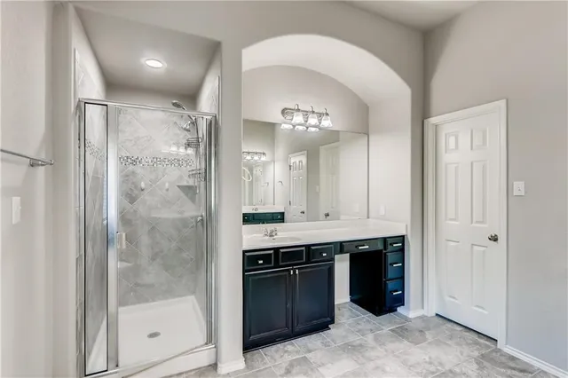 a bathroom with a double vanity sink mirror and shower
