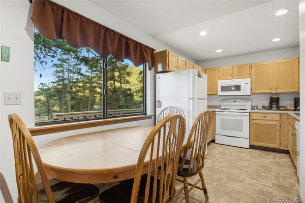 a kitchen with a table chairs sink and cabinets
