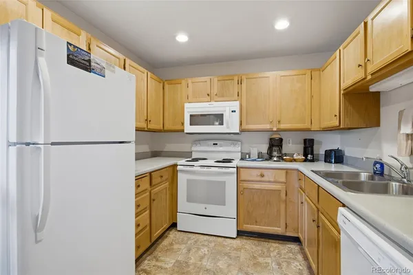 a kitchen with a sink a stove a refrigerator and cabinets
