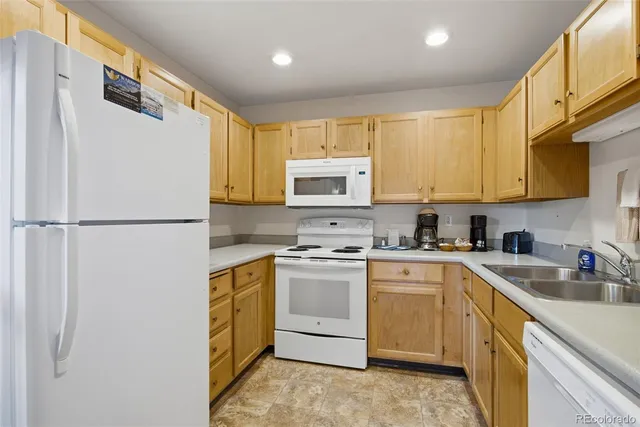 a kitchen with a sink a stove a refrigerator and cabinets