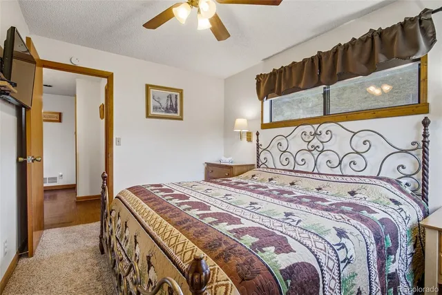 a bedroom with a bed and a painting on the wall