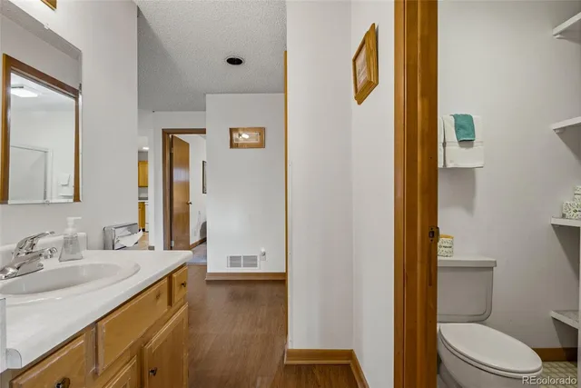 a bathroom with a granite countertop sink toilet and shower