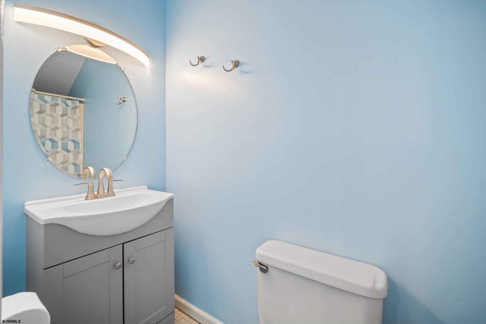 323 44th Street South, Unit 23 Brigantine, NJ 08203 - Photo 17 of 33 a bathroom with a toilet sink and mirror