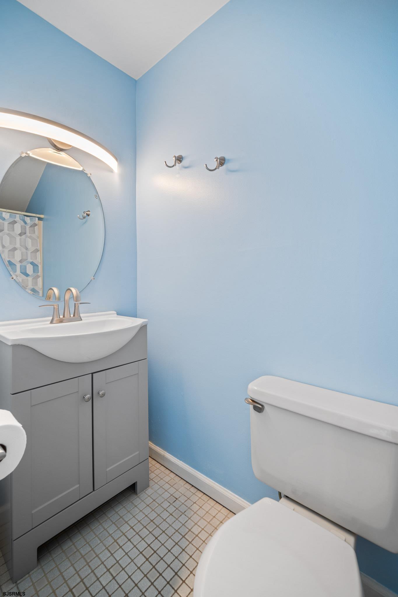 323 44th Street South, Unit 23 Brigantine, NJ 08203 - Photo 18 of 33 a bathroom with a toilet sink and mirror