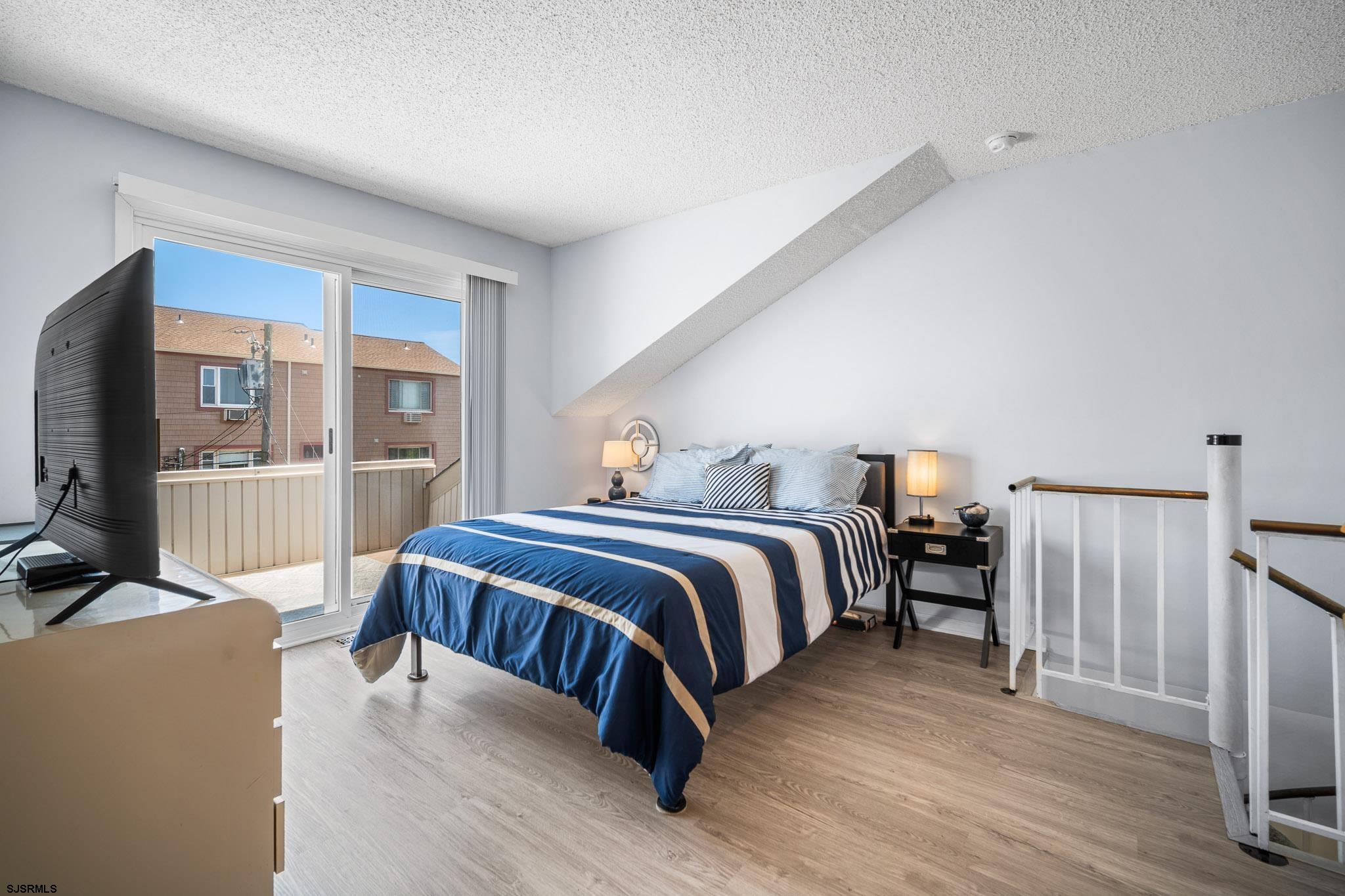 323 44th Street South, Unit 23 Brigantine, NJ 08203 - Photo 20 of 33 a bedroom with a bed and a flat tv screen on the dresser