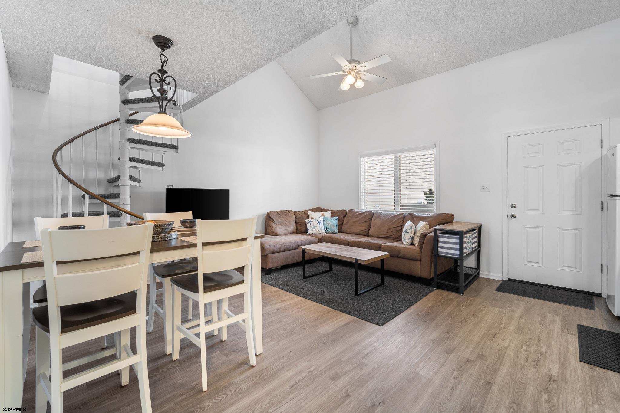 323 44th Street South, Unit 23 Brigantine, NJ 08203 - Photo 3 of 33 a living room with furniture a dining table and a chandelier
