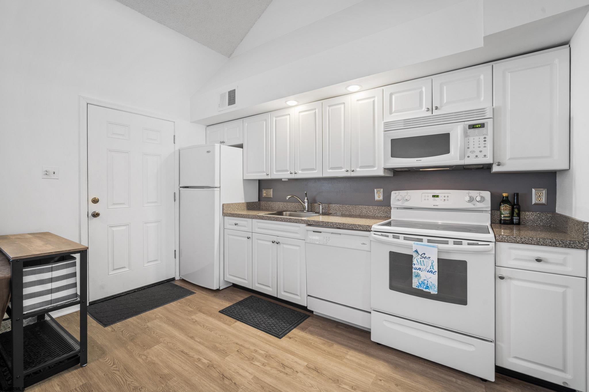 323 44th Street South, Unit 23 Brigantine, NJ 08203 - Photo 6 of 33 a kitchen with granite countertop white cabinets and white appliances