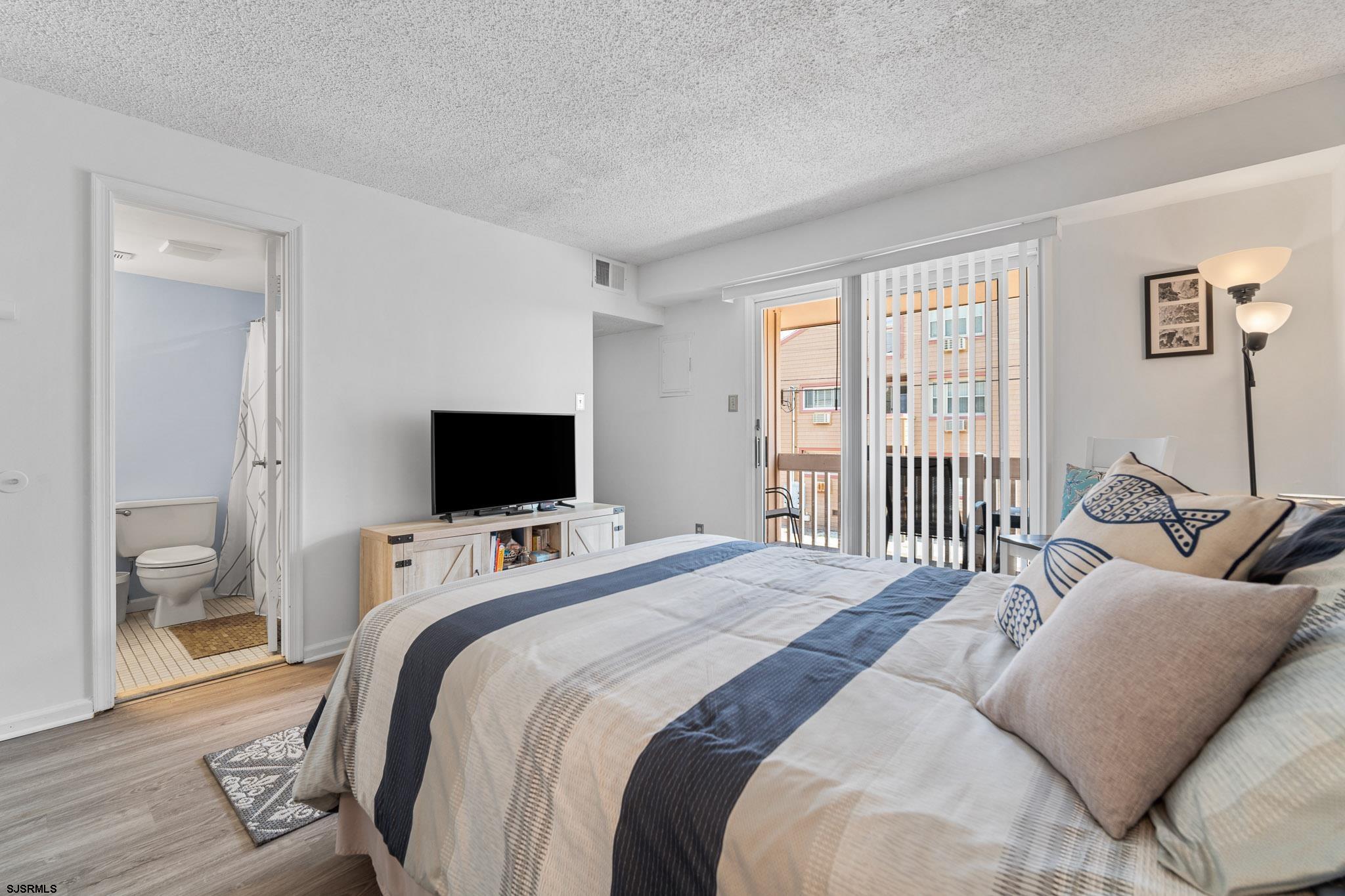 323 44th Street South, Unit 23 Brigantine, NJ 08203 - Photo 9 of 33 a bedroom with a bed and a flat screen tv