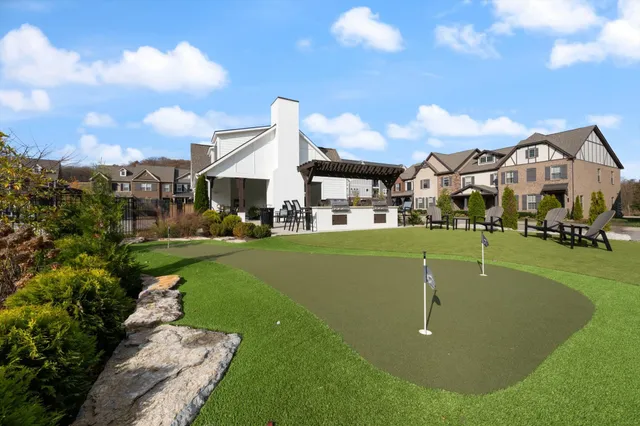 a view of a street with a yard and a large tree