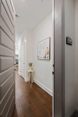 a view of a hallway with wooden floor and closet