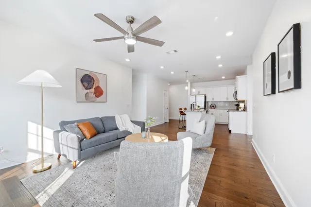 a living room with furniture and a view of kitchen