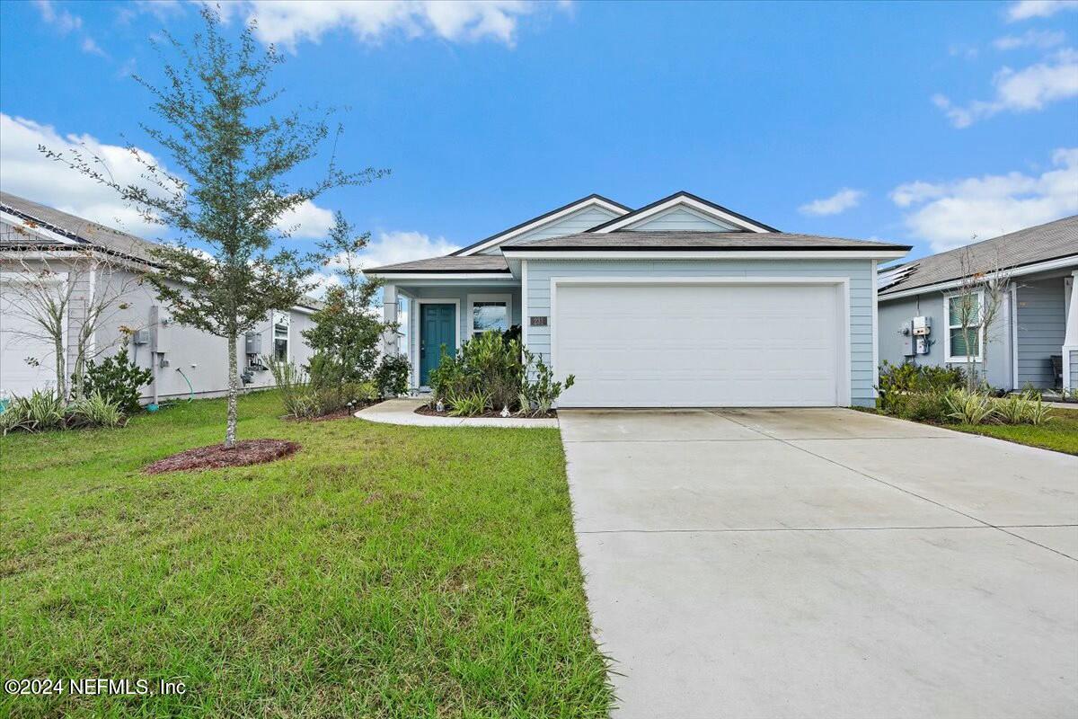 a front view of a house with a yard and garage