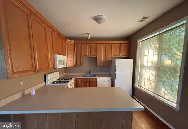 a kitchen with a refrigerator a stove a sink and cabinets