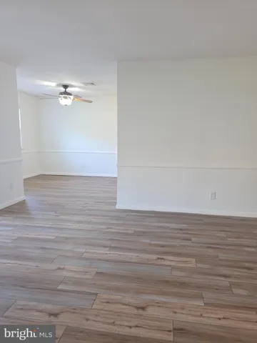 a view of empty room with window and wooden floor