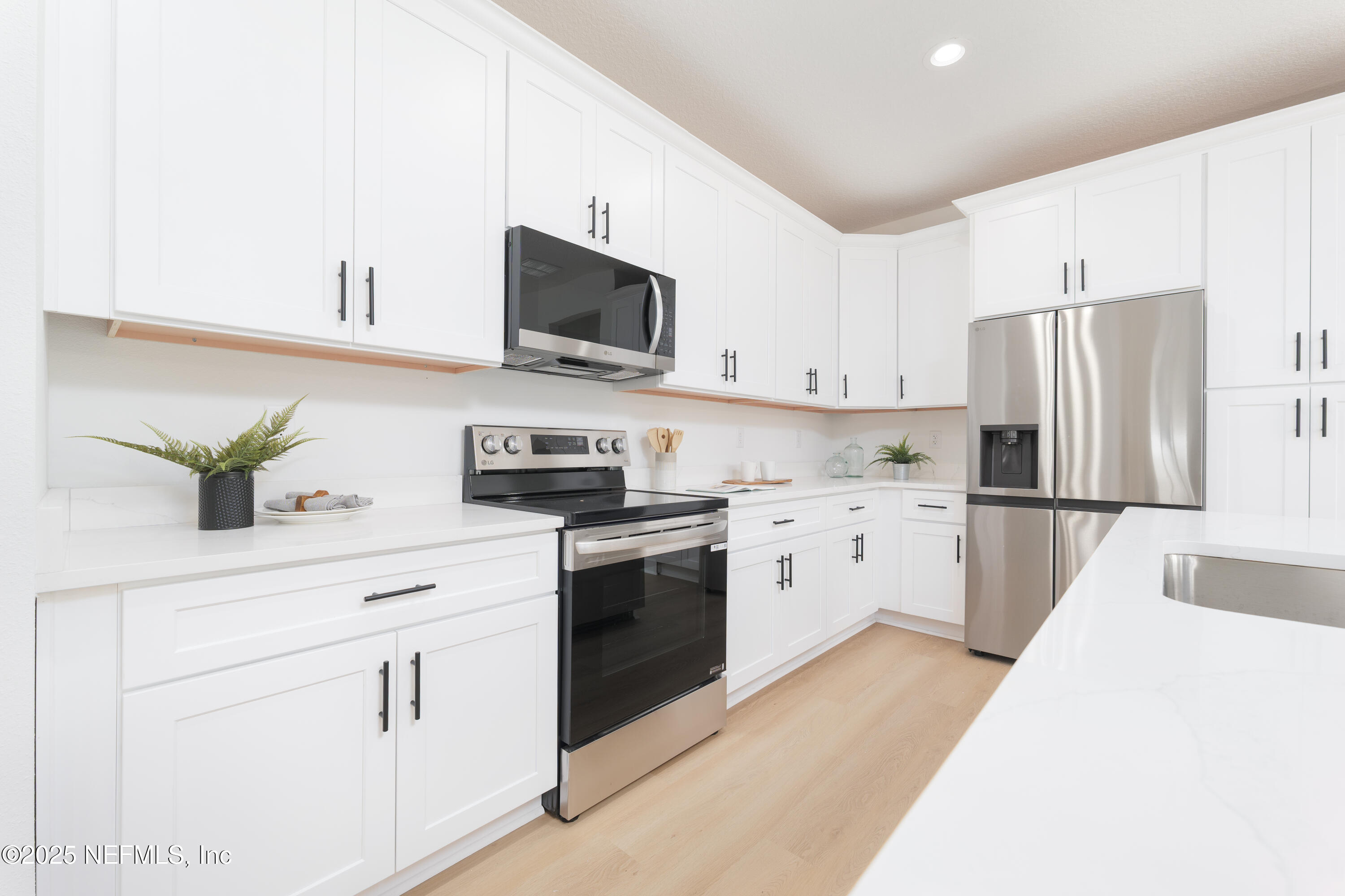5729 Chippewa Avenue Keystone Heights, FL 32656 - Photo 4 of 20 a kitchen with white cabinets and stainless steel appliances
