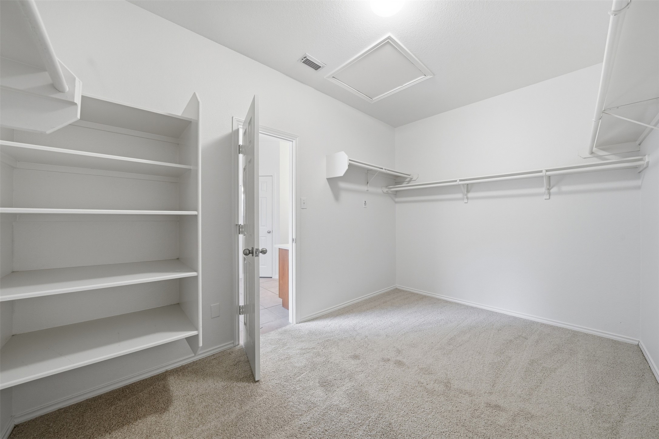118 Invierno Street Kyle, TX 78640 - Photo 30 of 37 A well-organized closet space with ample shelving and hanging rods for storage.