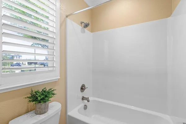 a bathroom with a granite countertop sink a mirror a bathtub and a shower