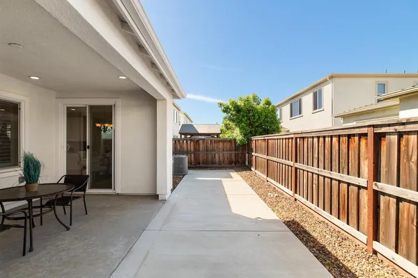 a view of a swimming pool with lawn chairs and a dining table under an umbrella