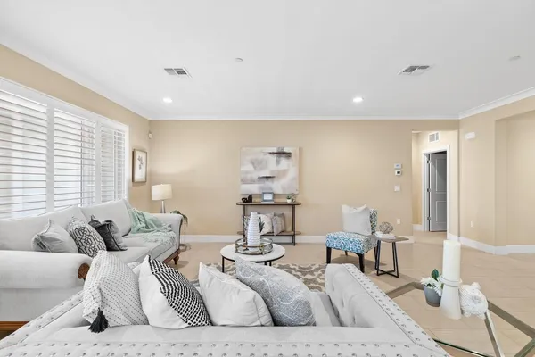 a living room with furniture kitchen view and wood floor