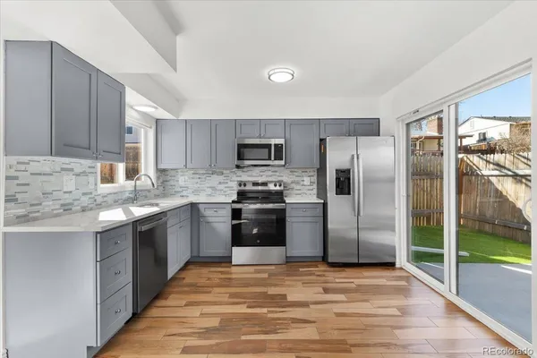 a kitchen with granite countertop a refrigerator and a sink